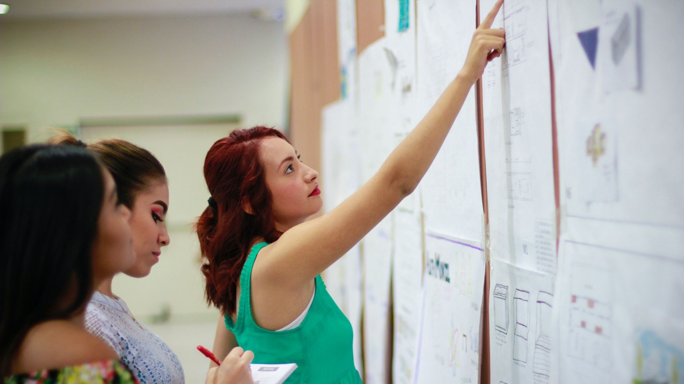 Teachers planning curriculum on a whiteboard.